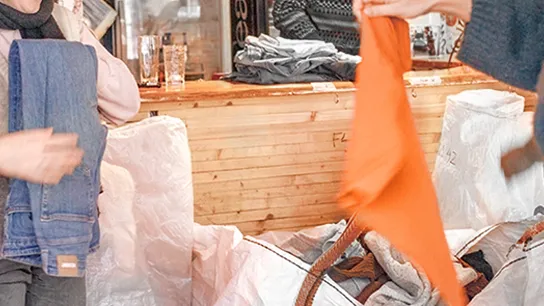 Fotos von jungen Menschen, die Kleidungsspenden sortieren